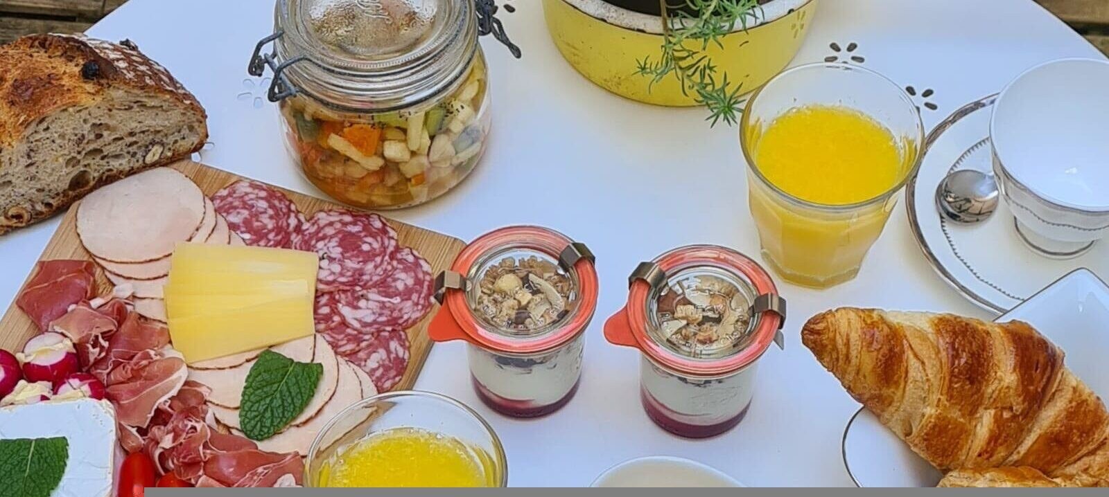 Brunch servi au Romarande avec croissants et produits frais